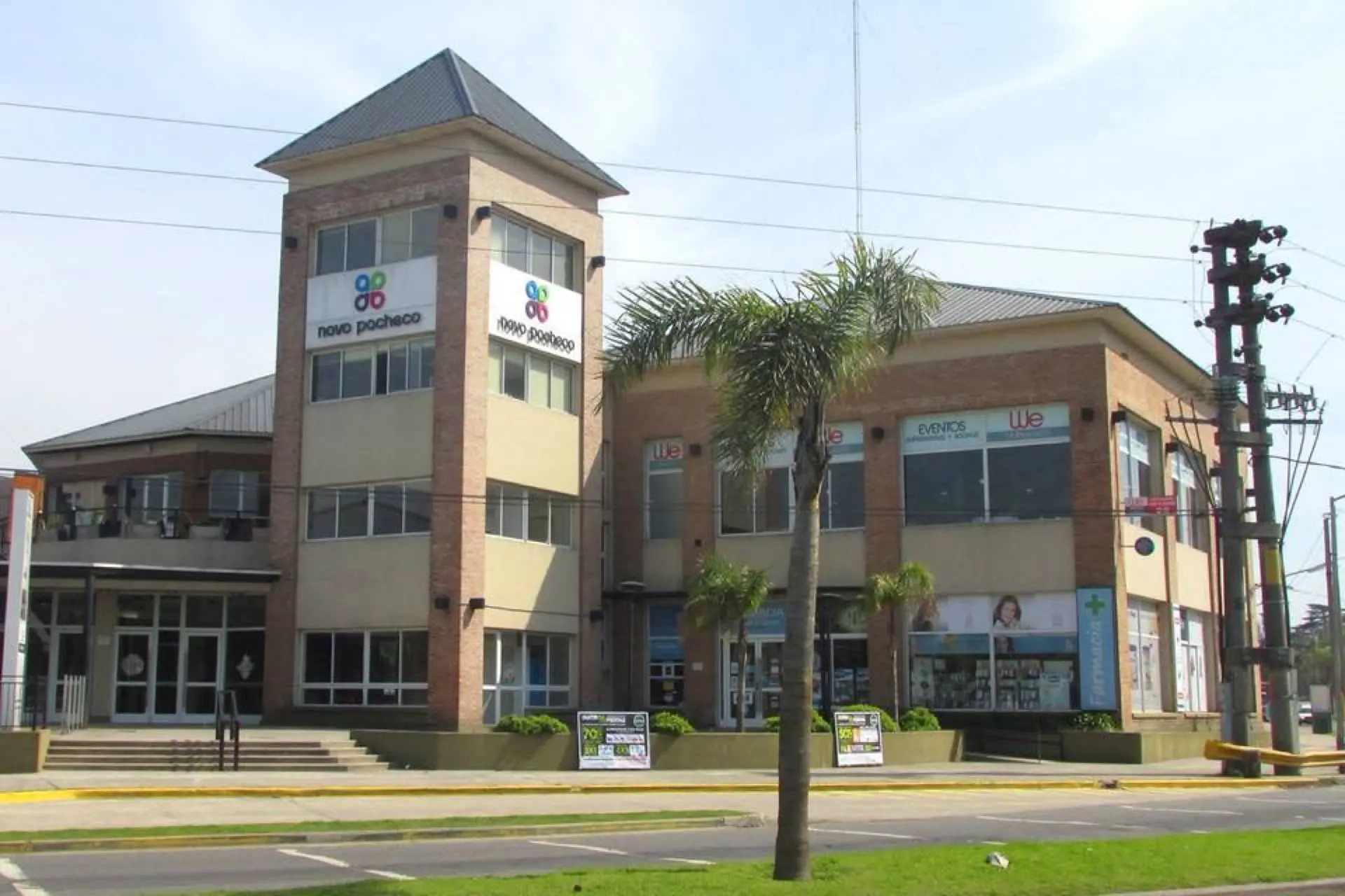 Fachada de ladrillo de Novo Pacheco con su torre y palmeras