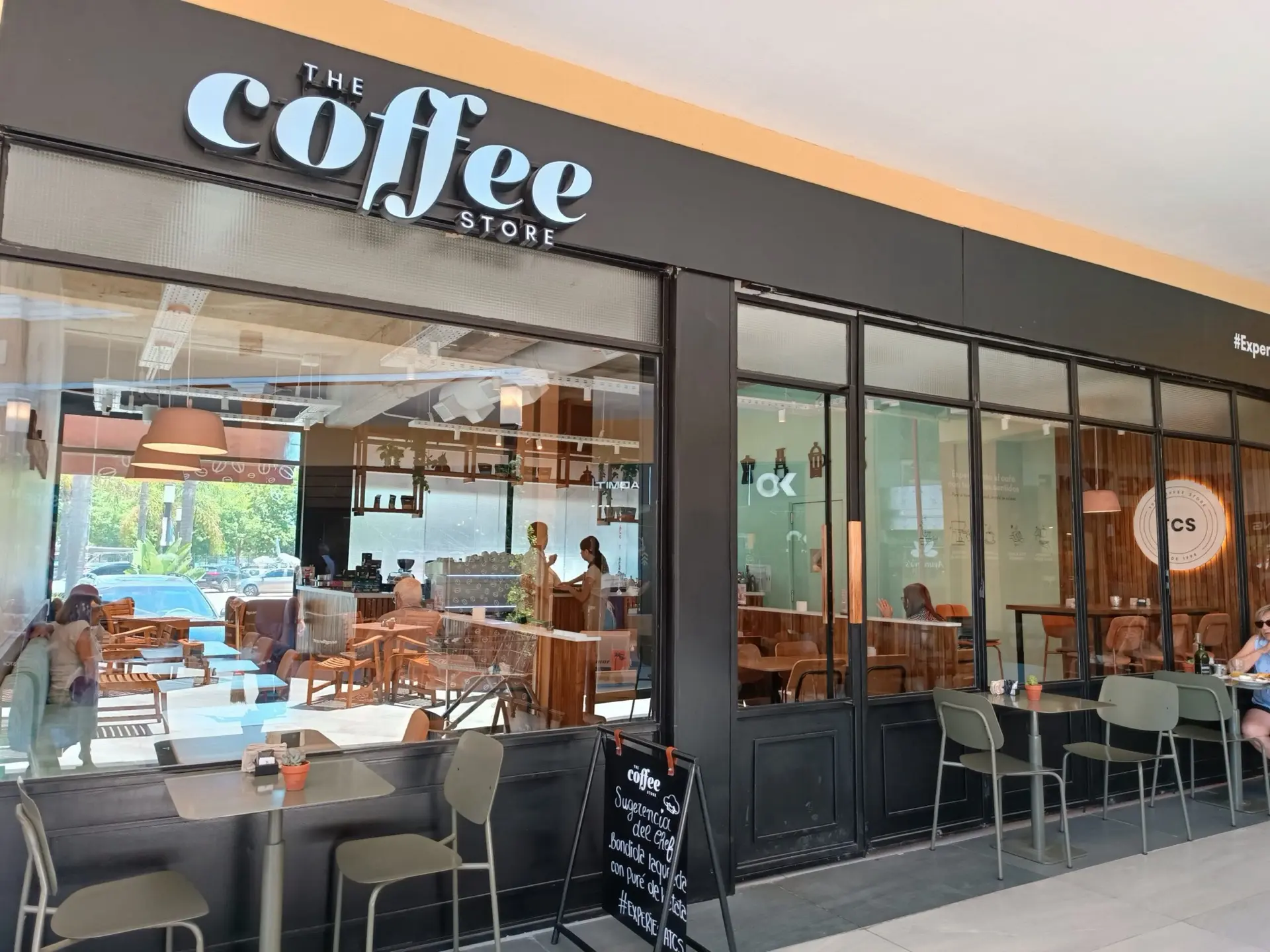 Frente de The Coffee Store en Paseo Pilar, con mesas en la galería