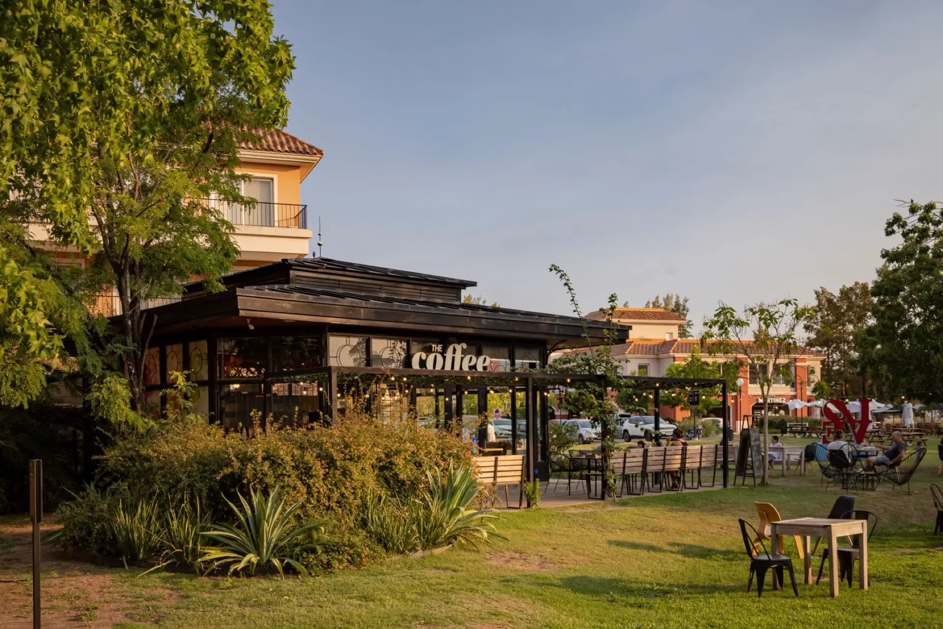Café con mesas en el parque de Pueblo Caamaño