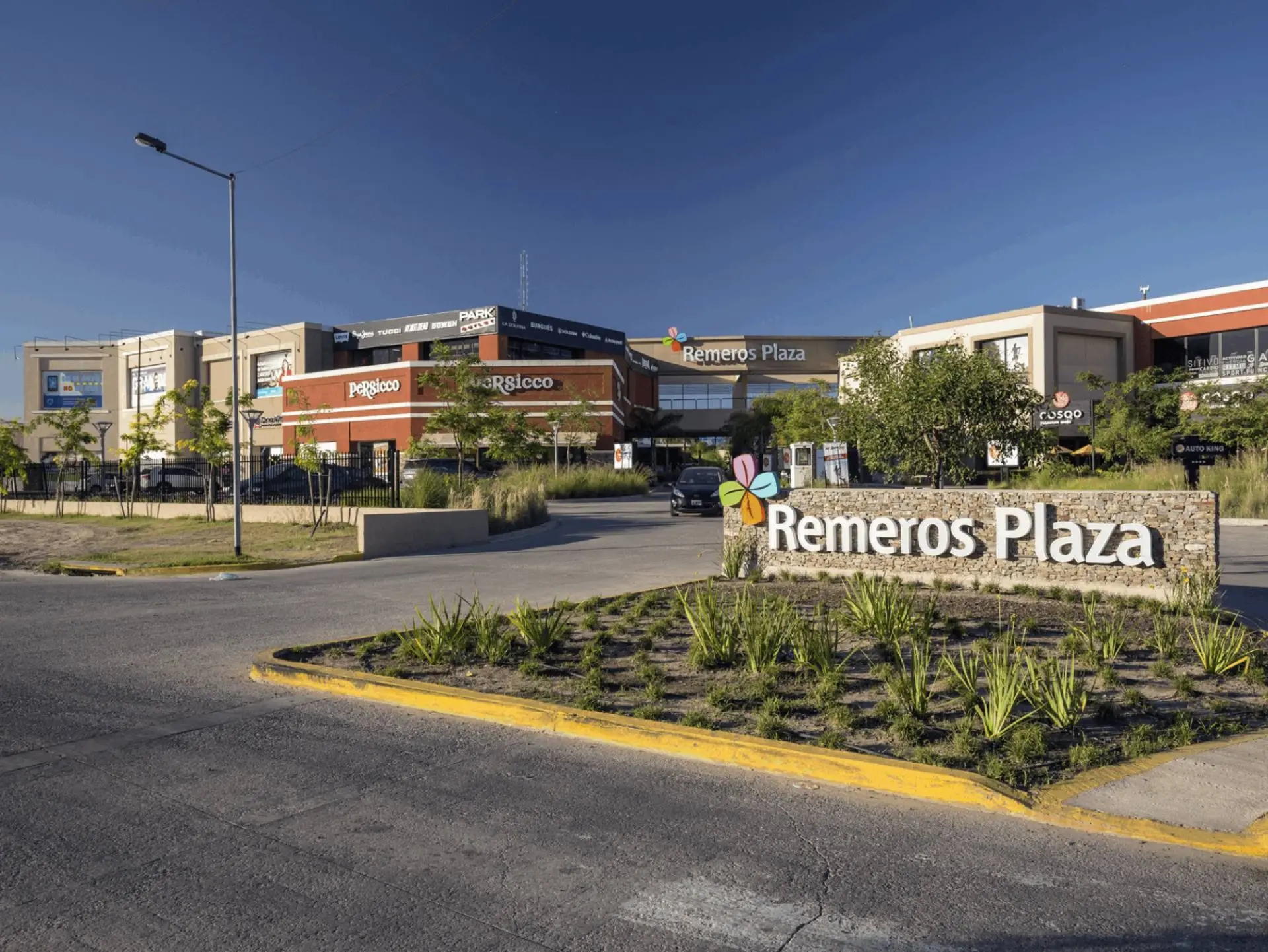 Acceso a Remeros Plaza con el cartel en un cantero