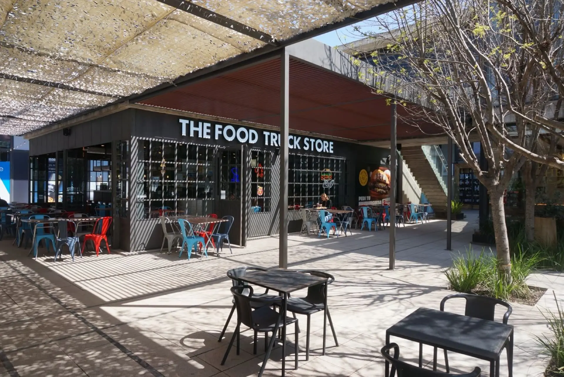 Patio con mesas frente a The Food Truck Store